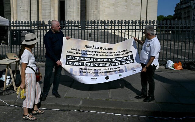 Des manifestants tiennent une banderole sur laquelle on peut lire "Non à la guerre, non à la tyrannie et à l'impérialisme de Khamenei, non au génocide de Gaza et à l'hégémonie de Netanyahu, les criminels contre l'humanité doivent être poursuivis et jugés, pour le droit des civils à vivre, pour un cessez-le-feu immédiat" alors qu'ils participent à une manifestation organisée par l'association "Iran justice" pour dénoncer le conflit en Iran, sur la place du Panthéon à Paris, le 19 juin 2025. (Crédit : Martin LELIEVRE / AFP)