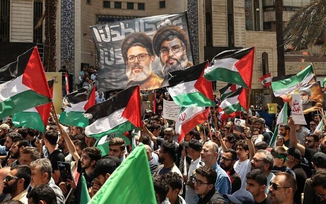 Des partisans du Hezbollah brandissant des drapeaux palestiniens et iraniens pour protester contre les attaques d'Israël contre la République islamique, après la prière du vendredi midi dans le fief du groupe terroriste chiite libanais, dans la banlieue sud de Beyrouth, au Liban, le 20 juin 2025. (Crédit : Anwar Amro/AFP) Des partisans du Hezbollah brandissant des drapeaux palestiniens et iraniens pour protester contre les attaques d'Israël contre la République islamique, après la prière du vendredi midi dans le fief du groupe terroriste chiite libanais, dans la banlieue sud de Beyrouth, au Liban, le 20 juin 2025. (Crédit : Anwar Amro/AFP)