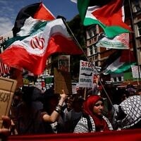 Des manifestants brandissant des drapeaux palestiniens et iraniens et tenant des pancartes sur lesquelles on peut lire « Arrêtez d'armer Israël » se rassemblent à Russell Square pour participer à une marche dans le centre de Londres, le 21 juin 2025, lors d'une manifestation organisée par la Campagne de solidarité avec la Palestine, appelant à « Non à la guerre contre l'Iran », « Arrêtez d'armer Israël », « Arrêtez d'affamer Gaza » et à la fin du « génocide ».(Crédit : Benjamin Cremel/AFP)