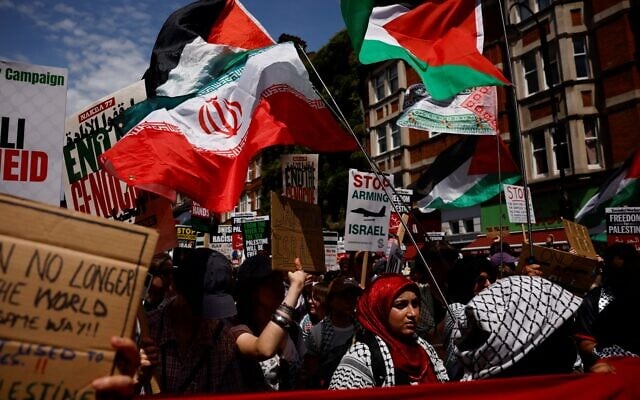 Des manifestants brandissant des drapeaux palestiniens et iraniens et tenant des pancartes sur lesquelles on peut lire « Arrêtez d'armer Israël » se rassemblent à Russell Square pour participer à une marche dans le centre de Londres, le 21 juin 2025, lors d'une manifestation organisée par la Campagne de solidarité avec la Palestine, appelant à « Non à la guerre contre l'Iran », « Arrêtez d'armer Israël », « Arrêtez d'affamer Gaza » et à la fin du « génocide ».(Crédit : Benjamin Cremel/AFP)