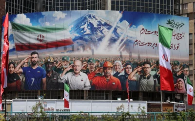 Une banderole représentant différentes catégories de la société iranienne est déployée sur la façade d'un immeuble de la place Valiasr à Téhéran, avec un message en farsi qui dit : "Nous sommes tous des soldats de l'Iran", le 22 juin 2025. (Crédit : AFP)