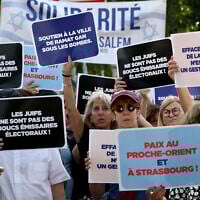 Des manifestants tiennent des pancartes devant l'hôtel de ville de Strasbourg lors d'un rassemblement organisé par le Conseil représentatif des institutions juives de France (CRIF) pour protester contre le projet de jumelage entre la ville de Strasbourg et le camp palestinien d'Aïda, à Strasbourg, dans l'est de la France, le 23 juin 2025. Le projet de jumelage de la Ville de Strasbourg avec le camp palestinien d'Aïda est soumis au vote du Conseil municipal le 23 juin 2025. (Crédit : FREDERICK FLORIN / AFP)