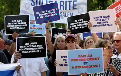 Des manifestants tiennent des pancartes devant l'hôtel de ville de Strasbourg lors d'un rassemblement organisé par le Conseil représentatif des institutions juives de France (CRIF) pour protester contre le projet de jumelage entre la ville de Strasbourg et le camp palestinien d'Aïda, à Strasbourg, dans l'est de la France, le 23 juin 2025. Le projet de jumelage de la Ville de Strasbourg avec le camp palestinien d'Aïda est soumis au vote du Conseil municipal le 23 juin 2025. (Crédit : FREDERICK FLORIN / AFP)