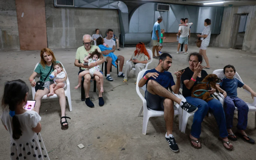 Des personnes réfugiées dans un abri souterrain à Tel Aviv le 24 juin 2025, après que des sirènes ont retenti dans plusieurs régions du pays à la suite du tir de missiles depuis l'Iran. (Crédit : Menahem Kahana/AFP)