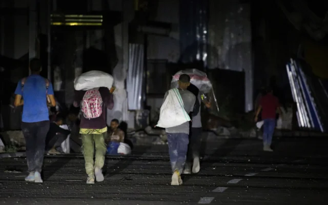 Des Palestiniens repartant avec des colis distribués par la Gaza Humanitarian Foundation (GHF), une organisation humanitaire privée, sur la route de Salaheddin, dans le camp de réfugiés de Nuseirat, dans le centre de la bande de Gaza, le 24 juin 2025. (Crédit : Eyad Baba/AFP) Des Palestiniens repartant avec des colis distribués par la Gaza Humanitarian Foundation (GHF), une organisation humanitaire privée, sur la route de Salaheddin, dans le camp de réfugiés de Nuseirat, dans le centre de la bande de Gaza, le 24 juin 2025. (Crédit : Eyad Baba/AFP)