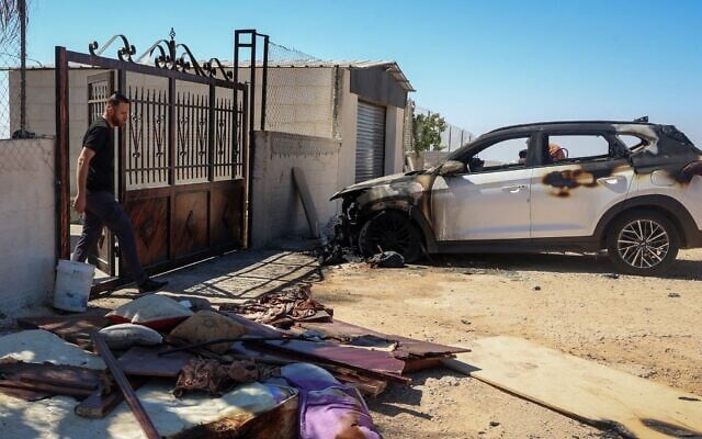 Un Palestinien marche près d'une voiture incendiée après une attaque de partisans pro-implantations israéliens survenue la veille dans le village de Kafr Malik, en Cisjordanie, le 26 juin 2025. (Crédit photo: Zain JAAFAR / AFP)
