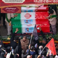 Des personnes en deuil assistent au cortège funèbre des commandants militaires et scientifiques iraniens tués lors des frappes israéliennes sur la place Enghelab (Place de la Révolution) dans la capitale Téhéran, le 28 juin 2025. (Crédit : ATTA KENARE / AFP)