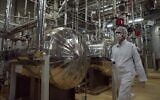 .Un responsable iranien de la sécurité en tenue de protection traverse une installation nucléaire juste à l'extérieur de la ville iranienne d'Ispahan, le 30 mars 2005. (Crédit : Vahid Salemi/AP)
