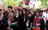 Des diplômés agitent des drapeaux palestiniens lors de cérémonies de remise des diplômes à l'Université Harvard, à Cambridge, dans le Massachusetts, le 29 mai 2025. (Crédit : AP Photo/Charles Krupa)