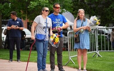 De gauche à droite : Carrie Spyva-McIlvaine, Gabriel Velasco et Lisa Turnquist arrivent pour déposer des bouquets de fleurs devant le mémorial improvisé devant le tribunal du comté de Boulder, dans le Colorado, après l'attaque perpétrée dimanche contre une marche en faveur des otages israéliens détenus par le Hamas, à Boulder, dans le Colorado, le 2 juin 2025. (Crédit : David Zalubowski/AP)