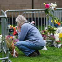 Un visiteur rend hommage aux victimes d'une manifestation de soutien aux otages israéliens détenus dans la bande de Gaza en déposant un bouquet de fleurs devant le palais de justice du comté de Boulder, dans le Colorado, le 3 juin 2025. (Crédit : David Zalubowski/AP)