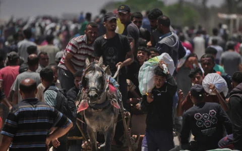 Des Palestiniens transportent des sacs contenant de la nourriture et des colis d'aide humanitaire livrés par la Fondation humanitaire de Gaza,  Rafah, dans le sud de la bande, le 9 juin 2025. (Crédit : AP Photo/Abdel Kareem Hana)