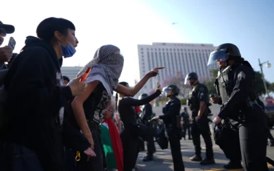 Des manifestants affrontent des membres des forces de l'ordre en tenue antiémeute dans le centre-ville de Los Angeles, le 9 juin 2025. (Crédit : AP/Eric Thayer)