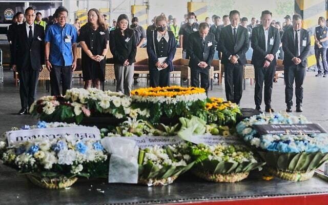 Narissara Chantasang (5ᵉ à partir de la gauche) épouse de Nattapong Pinta, un ouvrier thaïlandais pris en otage et tué par des terroristes à Gaza, assistant à une cérémonie commémorative silencieuse près du cercueil contenant son corps à l'aéroport international de Suvarnabhumi, dans la province de Samut Prakarn, en Thaïlande, le 11 juin 2025. (Crédit : Sakchai Lalit/AP) Narissara Chantasang (5ᵉ à partir de la gauche) épouse de Nattapong Pinta, un ouvrier thaïlandais pris en otage et tué par des terroristes à Gaza, assistant à une cérémonie commémorative silencieuse près du cercueil contenant son corps à l'aéroport international de Suvarnabhumi, dans la province de Samut Prakarn, en Thaïlande, le 11 juin 2025. (Crédit : Sakchai Lalit/AP)
