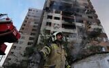 Un pompier appelant ses collègues sur les lieux d'une explosion dans un complexe résidentiel, au nord de Téhéran, en Iran, le 13 juin 2025. (Crédit : Vahid Salemi/AP)