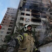 Un pompier appelant ses collègues sur les lieux d'une explosion dans un complexe résidentiel, au nord de Téhéran, en Iran, le 13 juin 2025. (Crédit : Vahid Salemi/AP)