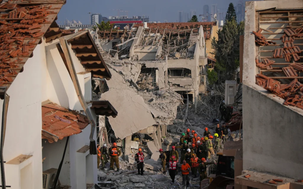 Les forces de sécurité israéliennes inspectant des maisons détruites par un missile tiré depuis l'Iran, à Rishon Lezion, en Israël, le 14 juin 2025. (Crédit : Ohad Zwigenberg/AP)