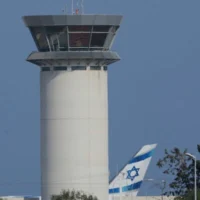 Un avion de la compagnie aérienne israélienne El AL à côté de la tour de contrôle du principal aéroport de Chypre à Larnaca, le 14 juin 2025. (AP/Petros Karadjias)