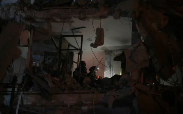 Les forces de sécurité israéliennes inspectent un immeuble détruit par un missile tiré depuis l'Iran, à Bat Yam, tôt le 15 juin 2025. (Crédit : AP/Ohad Zwigenberg) Les forces de sécurité israéliennes inspectent un immeuble détruit par un missile tiré depuis l'Iran, à Bat Yam, tôt le 15 juin 2025. (Crédit : AP/Ohad Zwigenberg)