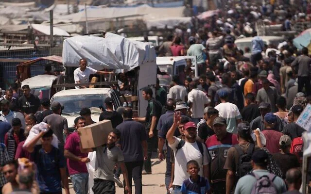 Des Palestiniens transportent des sacs contenant de la nourriture et des colis d'aide humanitaire livrés par la Fondation humanitaire pour Gaza, une organisation soutenue par les États-Unis, à Rafah, dans le sud de la bande de Gaza, le 15 juin 2025. (Crédit : Abdel Kareem Hana/AP) Des Palestiniens transportent des sacs contenant de la nourriture et des colis d'aide humanitaire livrés par la Fondation humanitaire pour Gaza, une organisation soutenue par les États-Unis, à Rafah, dans le sud de la bande de Gaza, le 15 juin 2025. (Crédit : Abdel Kareem Hana/AP)