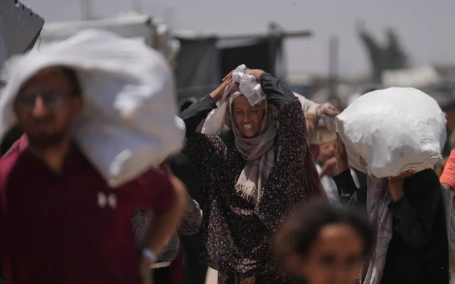 Des Palestiniens transportent des sacs contenant de la nourriture et des colis d'aide humanitaire distribués par la Fondation humanitaire de Gaza, une organisation soutenue par les États-Unis et Israël, à Rafah, dans le sud de la bande de Gaza, le lundi 16 juin 2025. (Crédit : AP Photo/Abdel Kareem Hana) Des Palestiniens transportent des sacs contenant de la nourriture et des colis d'aide humanitaire distribués par la Fondation humanitaire de Gaza, une organisation soutenue par les États-Unis et Israël, à Rafah, dans le sud de la bande de Gaza, le lundi 16 juin 2025. (Crédit : AP Photo/Abdel Kareem Hana)