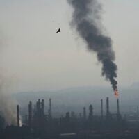 De la fumée s’élevant après qu'un missile iranien a frappé une raffinerie de pétrole à Haïfa, dans le nord d'Israël, au petit matin du 16 juin 2025. (Crédit : Ariel Schalit/AP)