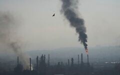 De la fumée s'échappant de la raffinerie de pétrole Bazan à Haïfa, dans le nord d'Israël, après avoir été bombardée par un missile iranien dans la nuit du 15 au 16 juin 2025. (Crédit : Ariel Schalit/AP)