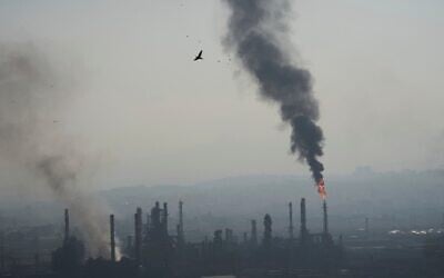De la fumée s'échappant de la raffinerie de pétrole Bazan à Haïfa, dans le nord d'Israël, après avoir été bombardée par un missile iranien dans la nuit du 15 au 16 juin 2025. (Crédit : Ariel Schalit/AP)