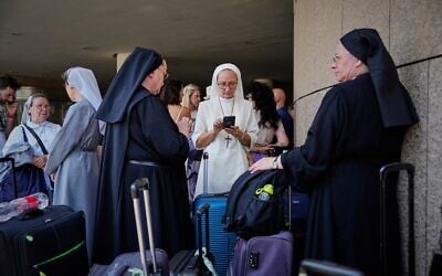 Des citoyens polonais et autrichiens réunis dans un hôtel à Tel Aviv, en Israël, pour être évacués au milieu des frappes iraniennes contre Israël, le 17 juin 2025. (Crédit : Baz Ratner/AP Photo)