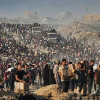 Des Palestiniens transportent des sacs et des boîtes contenant de la nourriture et de l'aide humanitaire déchargés d'un convoi du Programme alimentaire mondial qui se dirigeait vers la ville de Gaza, dans le nord de la bande de Gaza, le 16 juin 2025. (AP / Jehad Achrafi)