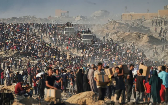 Des Palestiniens transportent des sacs et des boîtes contenant de la nourriture et de l'aide humanitaire déchargés d'un convoi du Programme alimentaire mondial qui se dirigeait vers la ville de Gaza, dans le nord de la bande de Gaza, le 16 juin 2025. (AP / Jehad Achrafi)