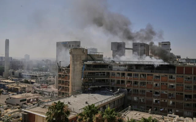 De la fumée s’élevant d'un bâtiment du complexe hospitalier Soroka à Beer Sheva après avoir été touché par un missile tiré depuis l'Iran, le 19 juin 2025. (Crédit : Leo Correa/AP)