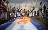 Des partisans houthis brûlant des drapeaux américains et d'Israël lors d'un rassemblement hebdomadaire anti-américain et anti-Israël, à Sanaa, au Yémen, le 20 juin 2025. (Crédit : Osamah Abdulrahman/AP)