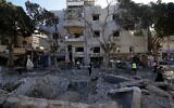 Des pompiers et des secouristes inspectant le site où un missile lancé depuis l'Iran a frappé Haïfa, en Israël, le 22 juin 2025. (Crédit : Baz Ratner/AP)