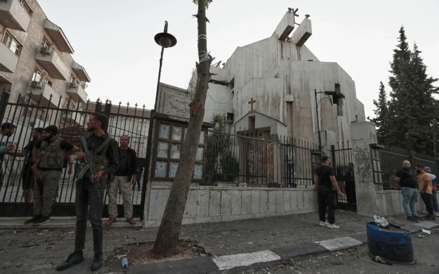 Les forces de sécurité syriennes montant la garde devant l'église Mar Elias où un kamikaze s'est fait exploser à Dweil'a, dans la banlieue de Damas, en Syrie, le 22 juin 2025. (Crédit : Omar Sanadiki/AP)