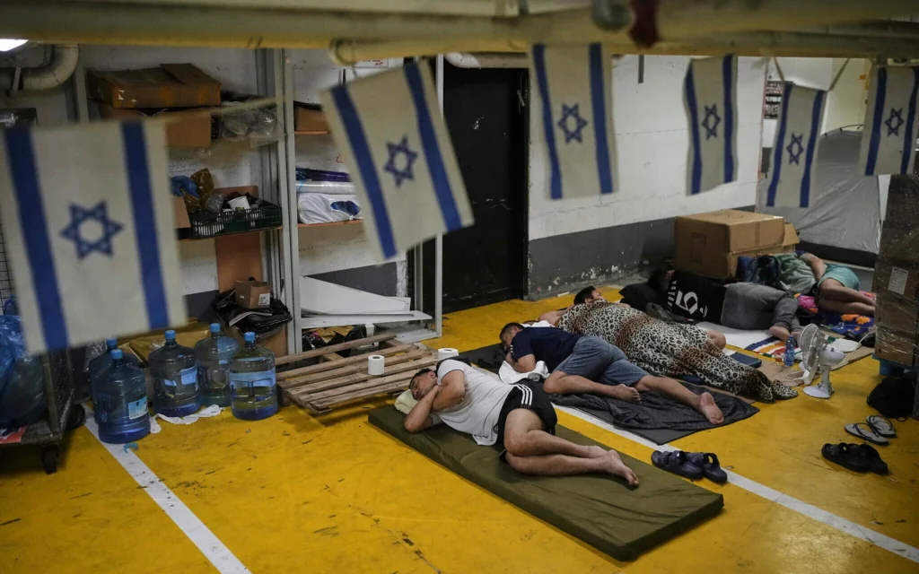 Des personnes réfugiées dans un parking souterrain par mesure de précaution contre d'éventuelles attaques de missiles iraniens, à Tel Aviv, le 24 juin 2025. (Crédit : Ohad Zwigenberg/AP)