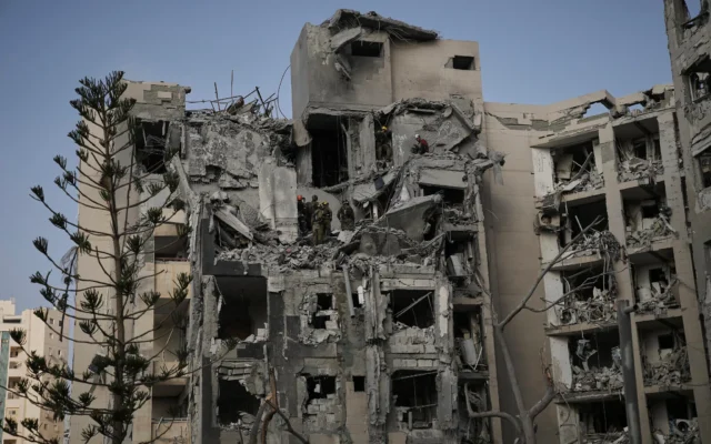 Des soldats israéliens et une équipe de secours recherchant des survivants parmi les décombres d'immeubles résidentiels détruits par un missile iranien qui a fait plusieurs morts, à Beer Sheva, en Israël, le 24 juin 2025. (Crédit : Leo Correa/AP)