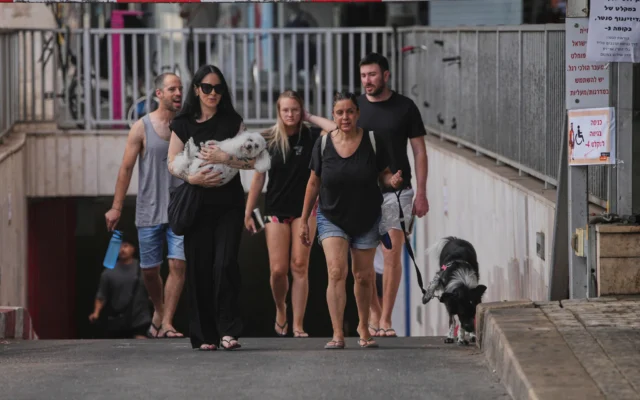 Des personnes quittant un parking souterrain où elles s'étaient réfugiées après une alerte aérienne annonçant des frappes de missiles iraniens, à Tel Aviv, en Israël, le 24 juin 2025. (Crédit : Ohad Zwigenberg/AP)