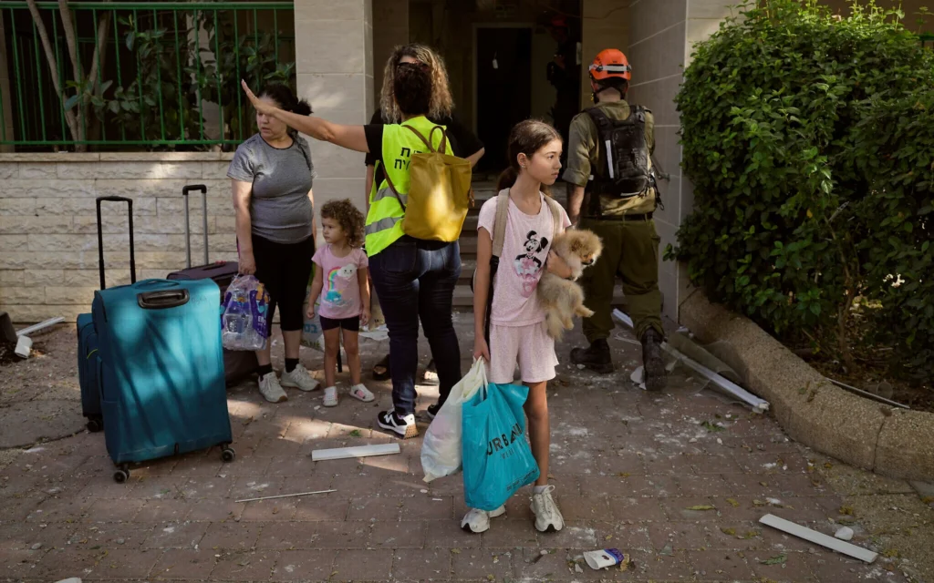 Des personnes évacuant un immeuble situé à côté d'un quartier touché par un missile iranien, où plusieurs personnes ont été tuées, à Beer Sheva, en Israël, le 24 juin 2025. (Crédit : Bernat Armangue/AP)