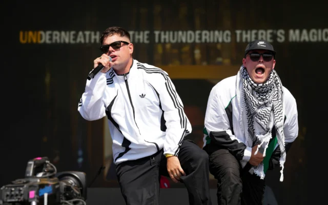 Naoise O Caireallain (à gauche) et Liam Og, du trio hip-hop Kneecap, se produisant lors du festival de Glastonbury, à Worthy Farm, dans le Somerset, en Angleterre, le 28 juin 2025. (Crédit : Scott A Garfitt/Invision/AP) Naoise O Caireallain (à gauche) et Liam Og, du trio hip-hop Kneecap, se produisant lors du festival de Glastonbury, à Worthy Farm, dans le Somerset, en Angleterre, le 28 juin 2025. (Crédit : Scott A Garfitt/Invision/AP)