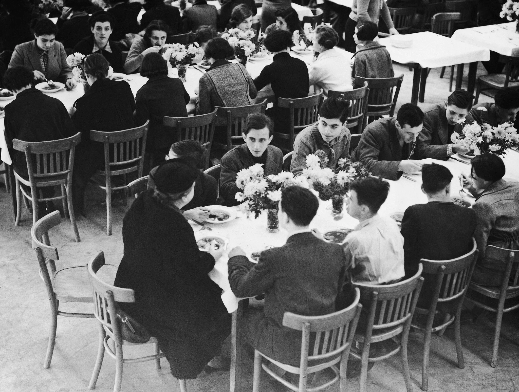 Deux cents réfugiés juifs arrivés d'Allemagne à Harwich le 2 décembre 1938 ont été emmenés dans le camp de vacances de Dovercourt Bay, jusqu'à ce que des dispositions soient prises pour les loger. Vue générale des tables lors du premier repas des réfugiés dans le camp. (Crédit : AP) Deux cents réfugiés juifs arrivés d'Allemagne à Harwich le 2 décembre 1938 ont été emmenés dans le camp de vacances de Dovercourt Bay, jusqu'à ce que des dispositions soient prises pour les loger. Vue générale des tables lors du premier repas des réfugiés dans le camp. (Crédit : AP)
