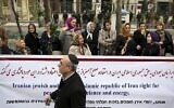 Un Juif iranien passe devant une bannière lors d’un rassemblement de la communauté juive iranienne devant un bureau de l’ONU à Téhéran, en Iran, le mardi 19 novembre 2013. (Photo AP/Ebrahim Noroozi)