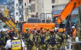 Les équipes de secours s'efforcent de retrouver les personnes disparues dans un immeuble détruit à Bat Yam à la suite d'une attaque meurtrière de missiles iraniens, le 15 juin 2025. (Crédit : Stav Levaton/Times of Israel)