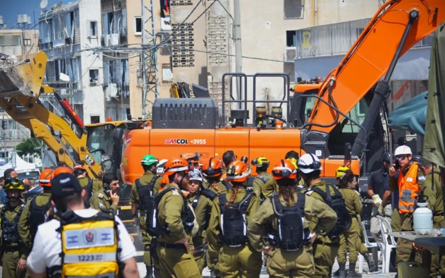 Les équipes de secours s'efforcent de retrouver les personnes disparues dans un immeuble détruit à Bat Yam à la suite d'une attaque meurtrière de missiles iraniens, le 15 juin 2025. (Crédit : Stav Levaton/Times of Israel)