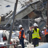 Des équipes israéliennes s'efforcent d'évaluer les dégâts et de déblayer les décombres à Bnei Brak après qu'une école locale a été touchée par un missile iranien, le 16 juin 2025. (Crédit : Stav Levaton/Times of Israel)