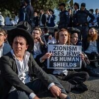 Des manifestants ultra-orthodoxes résistant aux forces de police lors d'une manifestation contre la conscription des jeunes haredim, près de Bnei Brak, le 5 juin 2025. (Crédit : Erik Marmor/Flash90)
