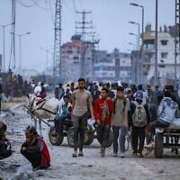 Des Palestiniens marchant près d'un point de distribution d'aide humanitaire dans le corridor de Netzarim, dans le centre de la bande de Gaza, le 9 juin 2025. (Crédit : Ali Hassan/Flash90)