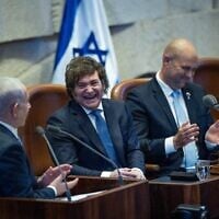 Le président argentin Javier Milei riant pendant que le Premier ministre Benjamin Netanyahu s'exprime lors d'une session plénière extraordinaire de la Knesset en l'honneur du dirigeant sud-américain en visite, le 11 juin 2025. (Crédit : Yonatan Sindel/Flash90)