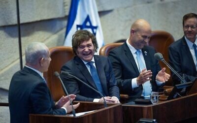 Le président argentin Javier Milei riant pendant que le Premier ministre Benjamin Netanyahu s'exprime lors d'une session plénière extraordinaire de la Knesset en l'honneur du dirigeant sud-américain en visite, le 11 juin 2025. (Crédit : Yonatan Sindel/Flash90)