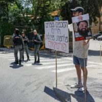 n manifestant se tient devant la résidence du Premier ministre Benjamin Netanyahu, malgré une directive du Commandement de la défense intérieure de l'armée israélienne demandant de rester à proximité des abris, pour réclamer un accord visant à libérer les otages détenus par des groupes terroristes à Gaza et à mettre fin à la guerre dans cette région, le 13 juin 2025. (Crédit : Rachel Alroey/FLASH90)
